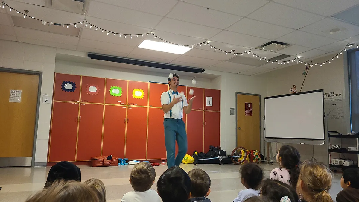 Philémon animant un atelier de jonglerie dans une école devant des enfants
